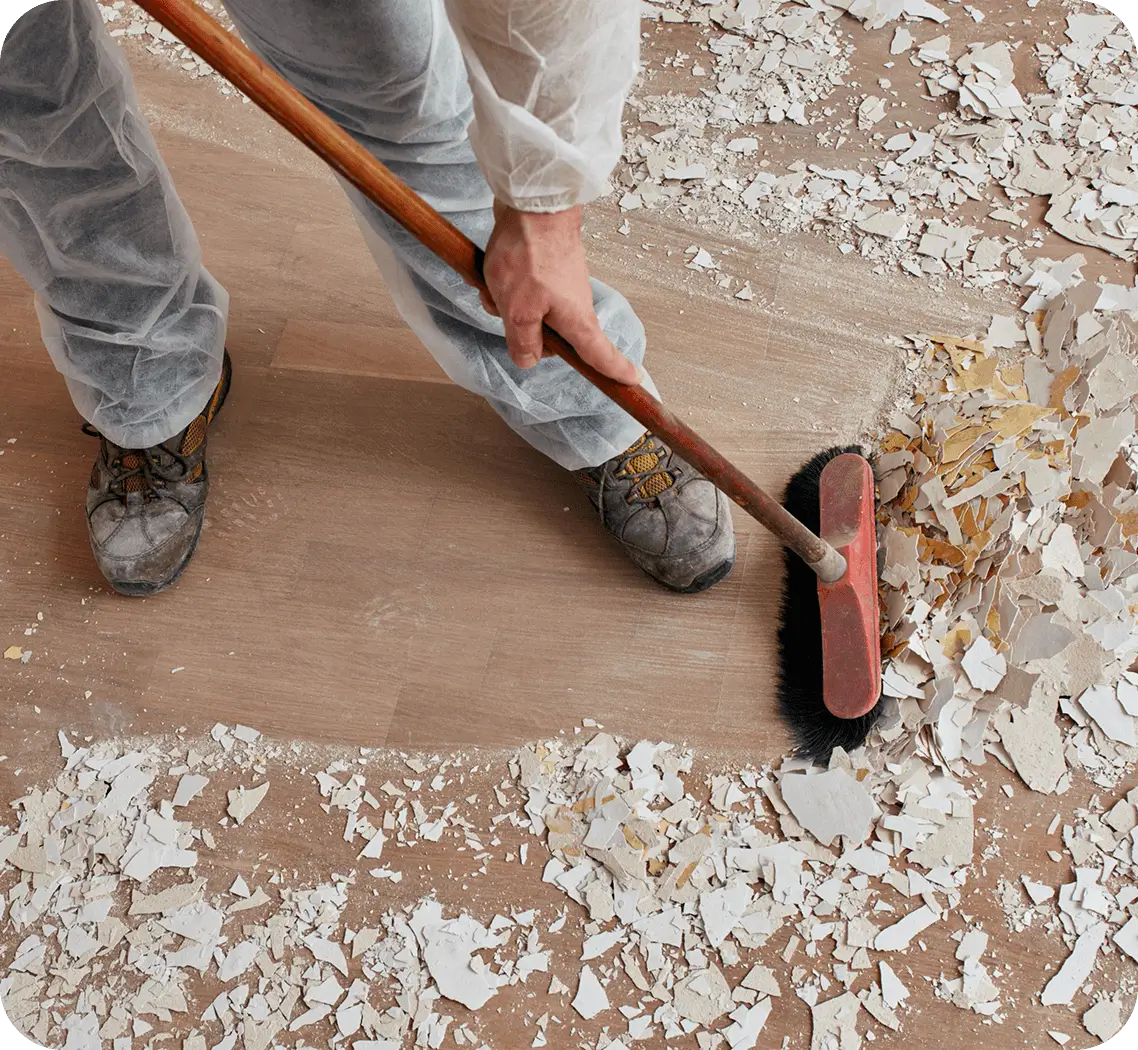 Person removing old flooring with a roller tool.